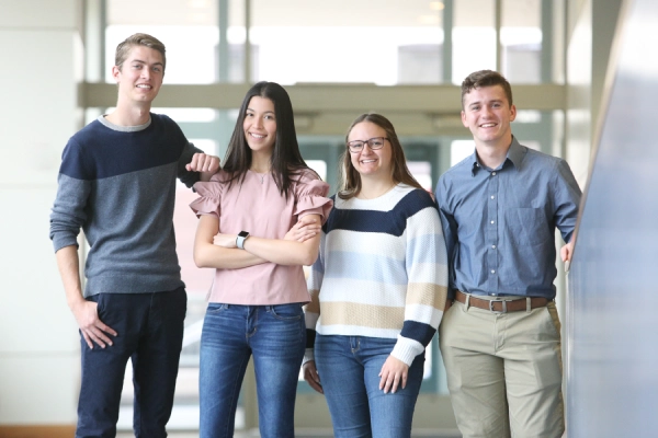 a group of four smiling students