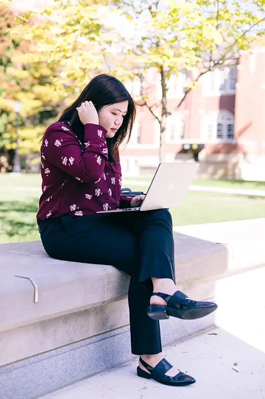 Student outside on laptop